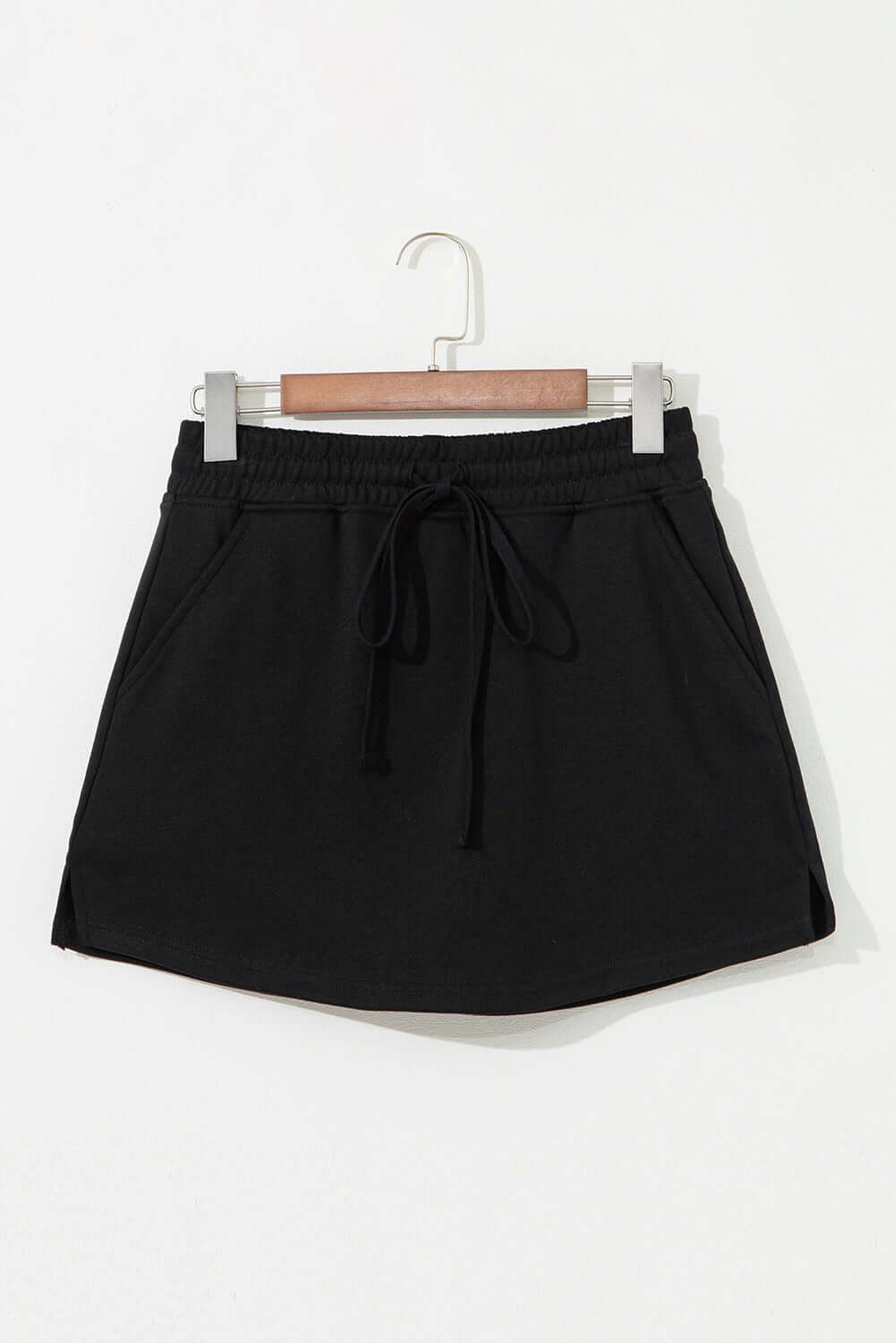 Black French terry drawstring skort featuring a casual design and side pockets.