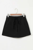 Black French terry drawstring skort featuring a casual design and side pockets.