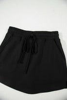 Black French terry drawstring skort with pockets and adjustable waist for casual comfort.
