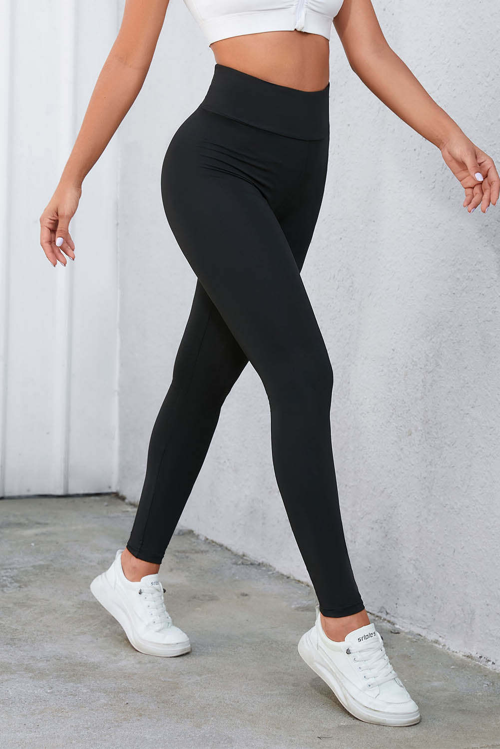 High-waisted black leggings with crisscross detail, perfect for gym and casual wear.