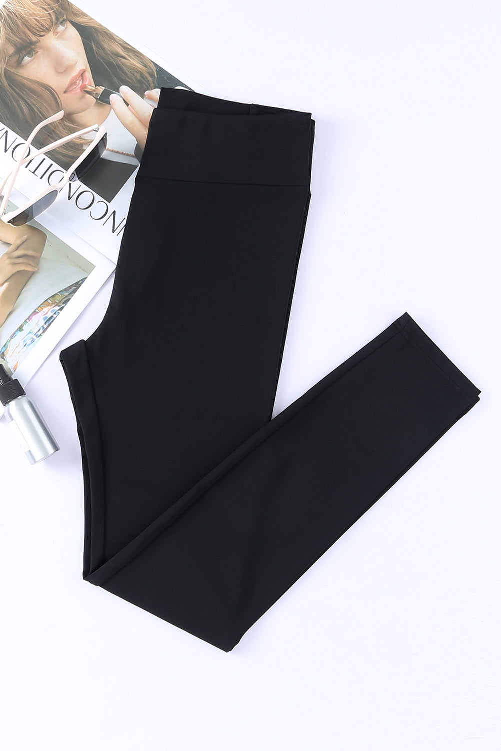 black high-waisted leggings with crisscross detail on magazine background