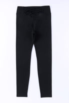 High-waisted black leggings with crisscross detail, designed for comfort and style, ideal for gym or everyday wear.