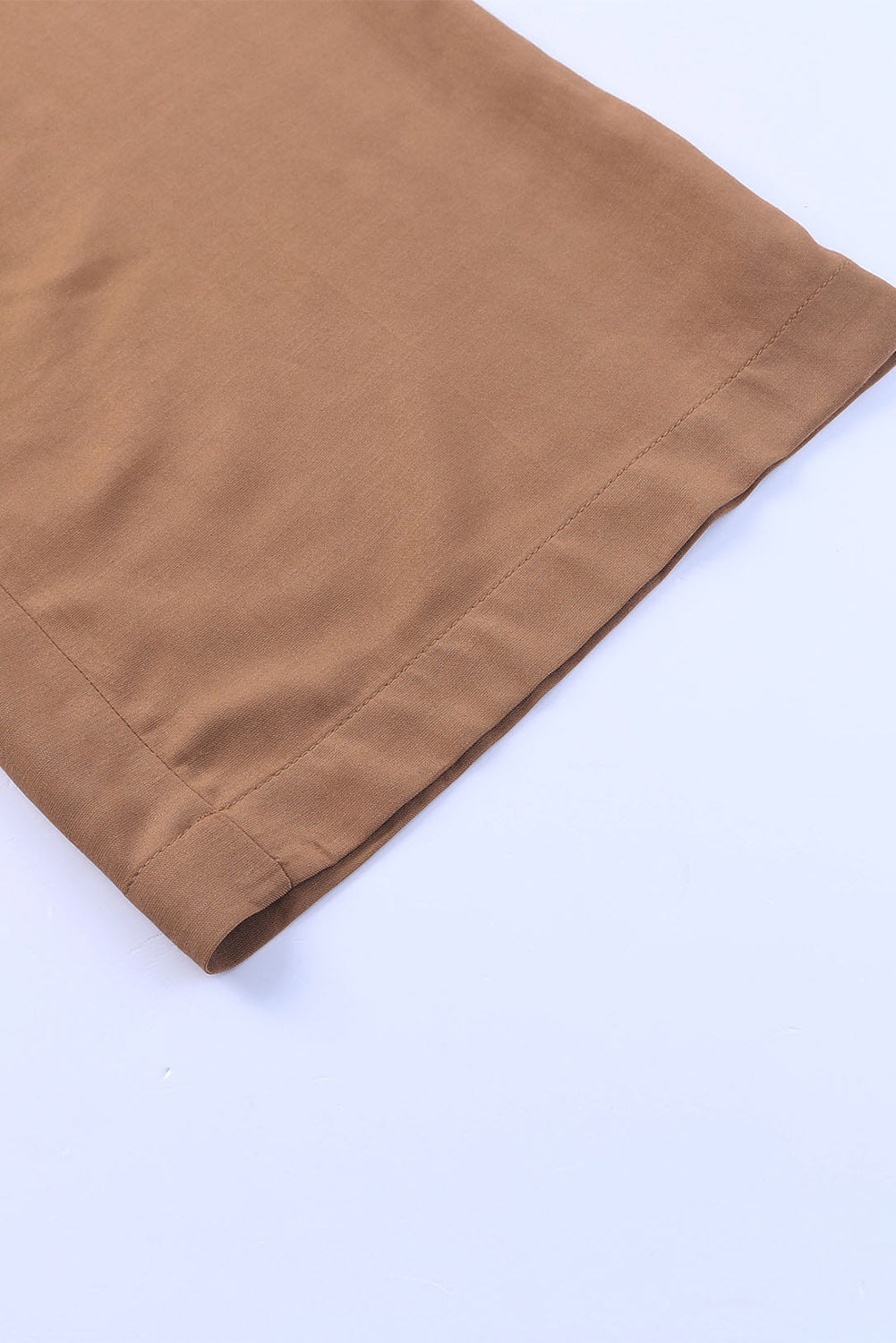 Close-up of caramel latte wide leg pants showcasing the hem and fabric texture in a stylish, versatile design.