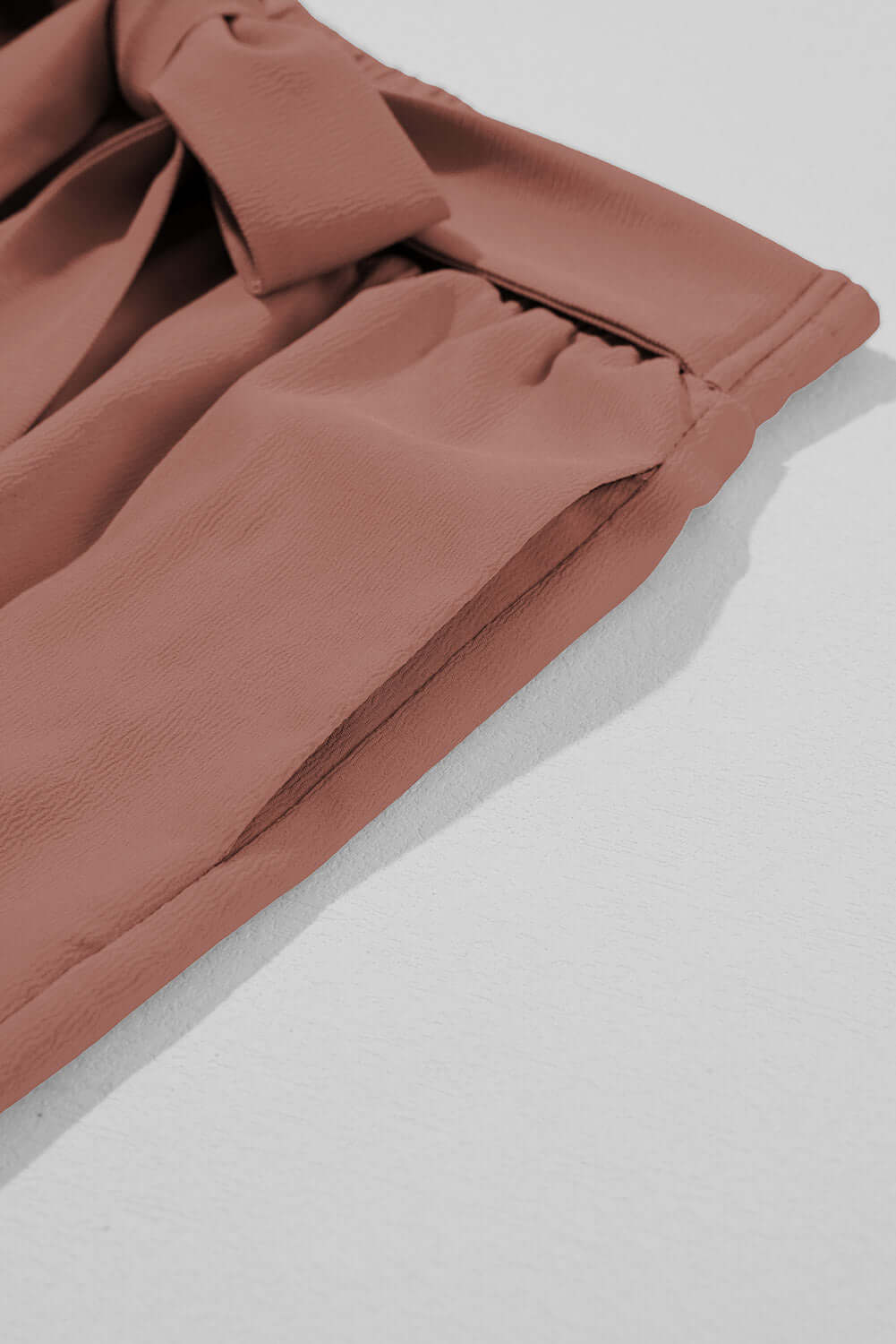 Detail of cocoa City Sway Wide Leg Pants showing tie-front sash and soft fabric texture.