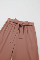 Close-up of cocoa City Sway wide-leg pants with tie-front sash and elastic waistband for a stylish fit.