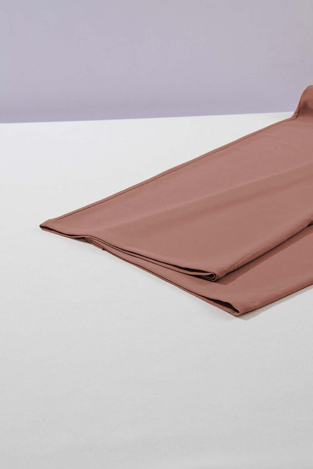 Folded cocoa fabric showcasing a soft texture, ideal for stylish wide-leg pants.