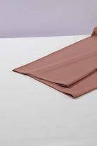 Folded cocoa fabric showcasing a soft texture, ideal for stylish wide-leg pants.