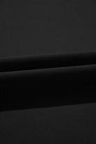 Close-up of soft black fabric texture, showcasing a smooth, flowy material ideal for wide leg pants.