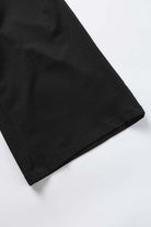 Close-up of the hem of City Sway Wide Leg Pants in black, showcasing soft fabric and relaxed fit.
