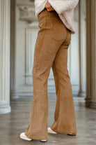 High waist corduroy flared pants with checkered pattern, showcasing a retro-inspired look against elegant interior background.