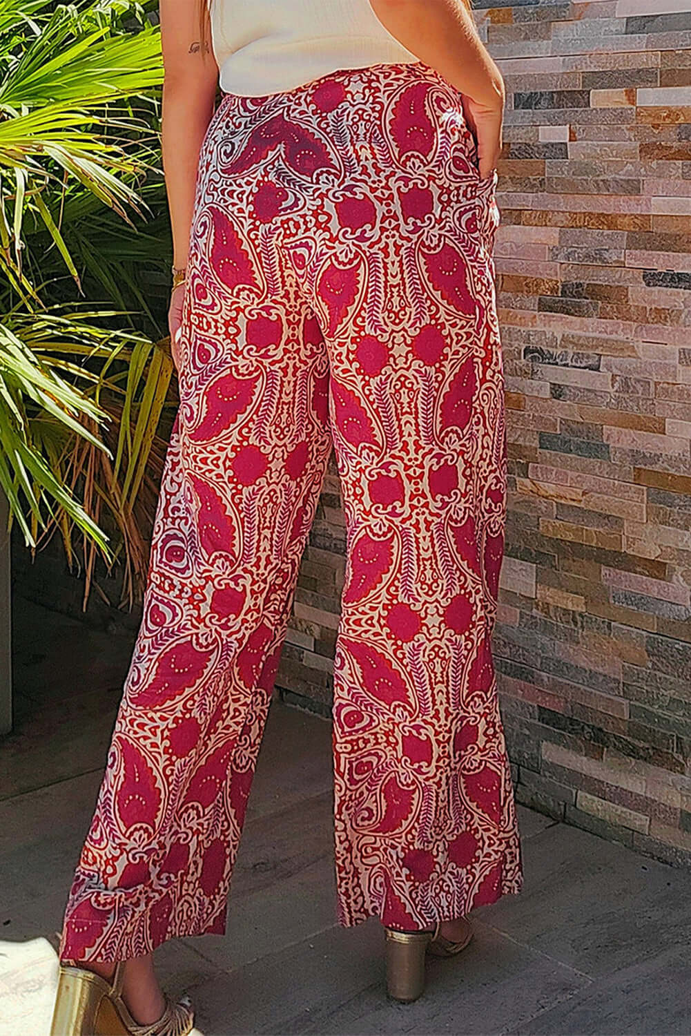 Back view of chic Boho Glam wide leg pants in red and cream abstract print, featuring a high waist and functional pockets.