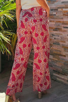 Back view of chic Boho Glam wide leg pants in red and cream abstract print, featuring a high waist and functional pockets.