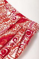 Close-up of Boho Glam wide leg pants featuring red and cream abstract pattern and button detailing.