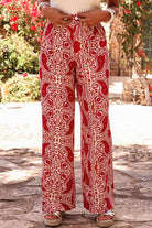 Boho glam wide leg pants in red and cream abstract motif, with high waist design and button detailing.