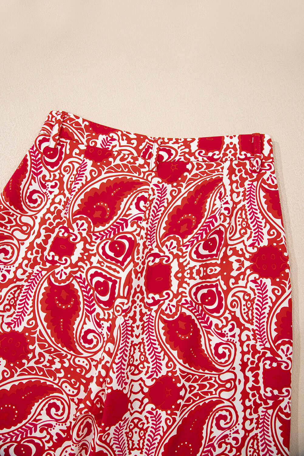Close-up of Boho Glam Wide Leg Pants in red and cream abstract motif featuring button detailing.