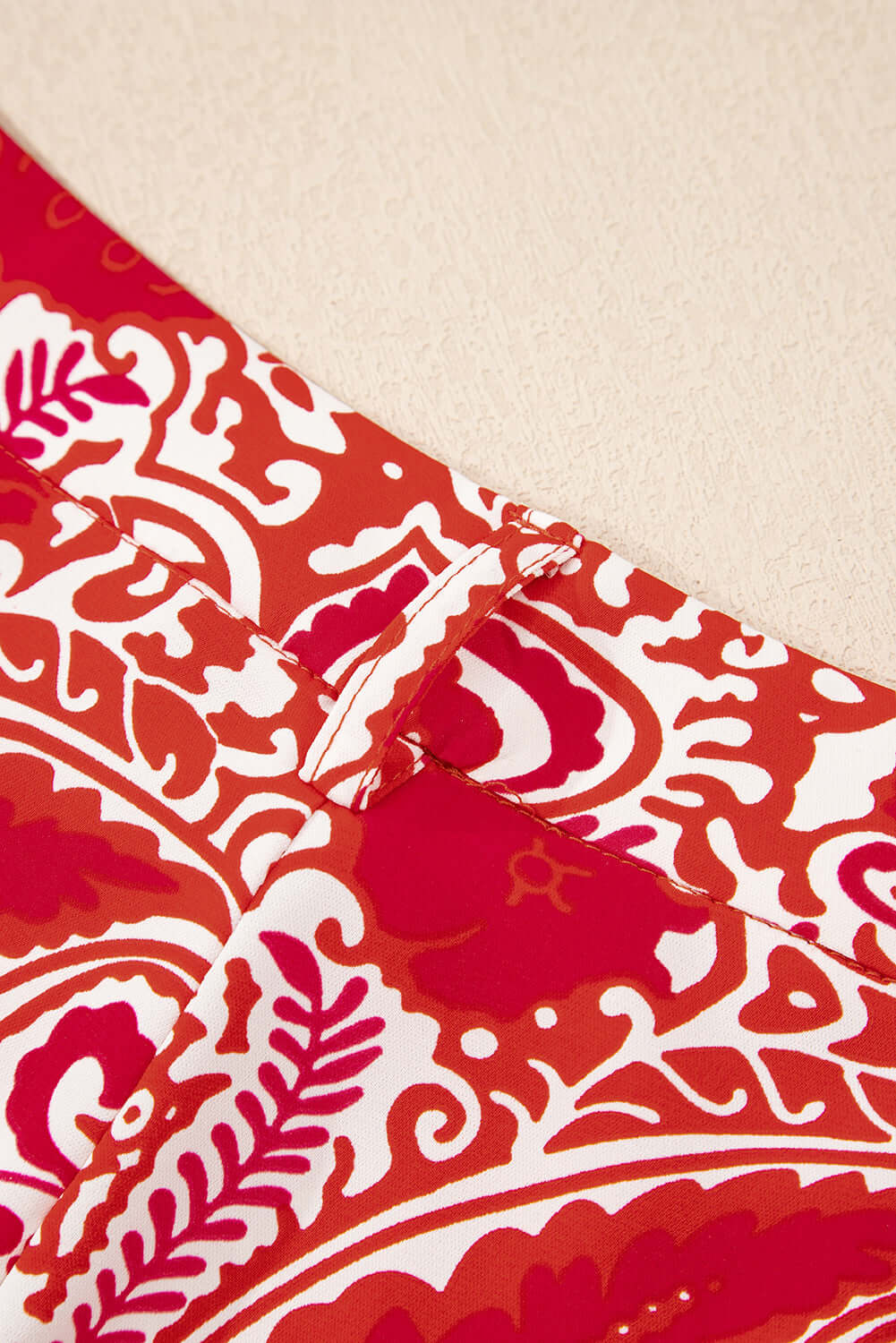 Close-up of red and cream abstract pattern on Boho Glam Wide Leg Pants with button detailing.