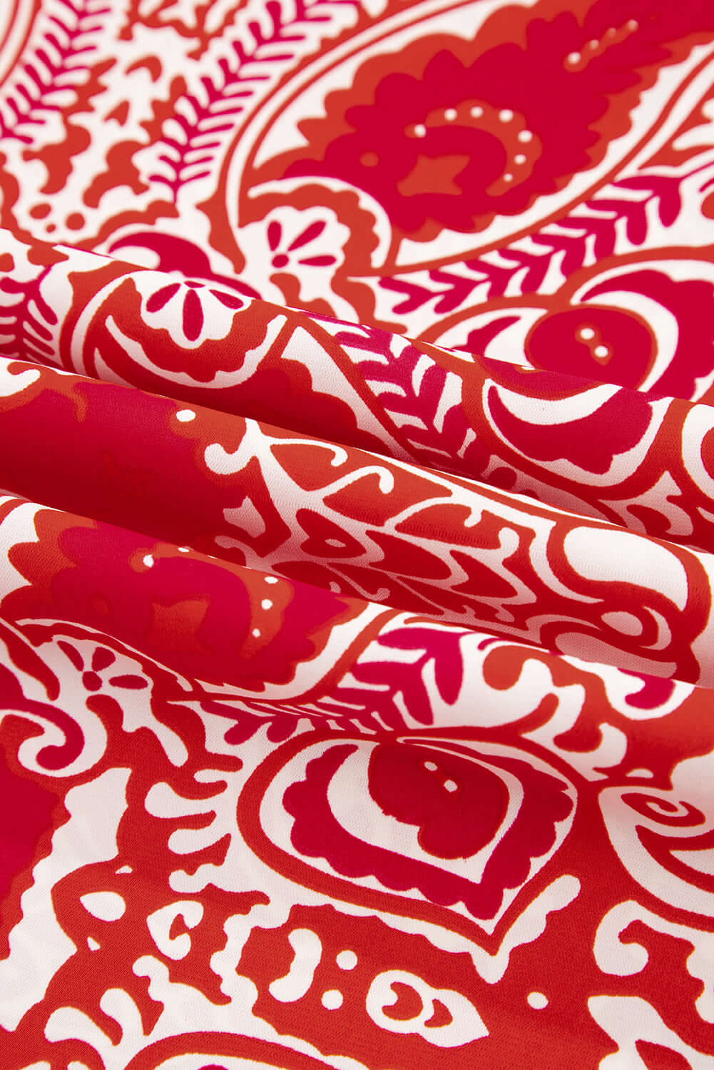 Close-up of red and cream fabric with abstract boho motifs, perfect for stylish wide-leg pants.