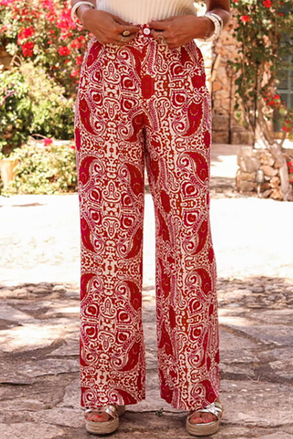 Boho glam wide leg pants in red and cream abstract pattern, featuring high waist and tailored button detailing.
