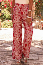 Chic red and cream abstract motif wide leg pants with high waist design and button detailing, perfect for boho glam style.