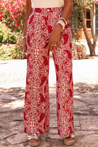 Stylish boho glam wide leg pants in red and cream abstract motif, featuring a high waist and elegant button detailing.