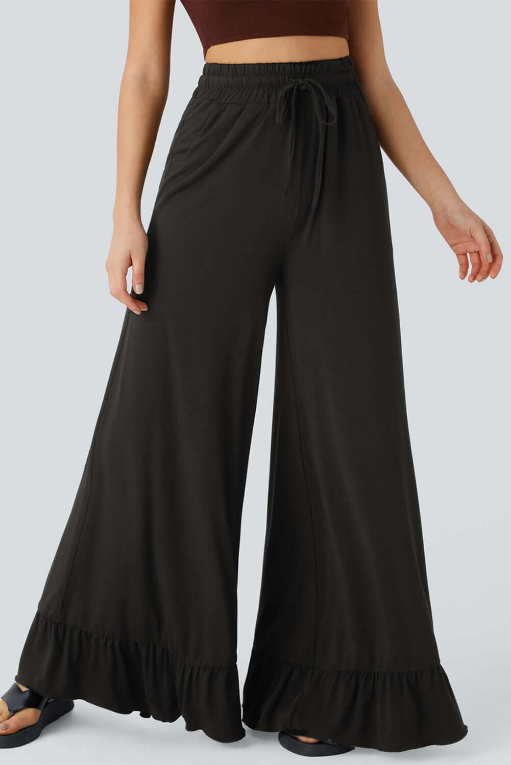 Charmingly styled model in CHARMED COMFORT WIDE LEG PANTS featuring a high waist and ruffled hem design.