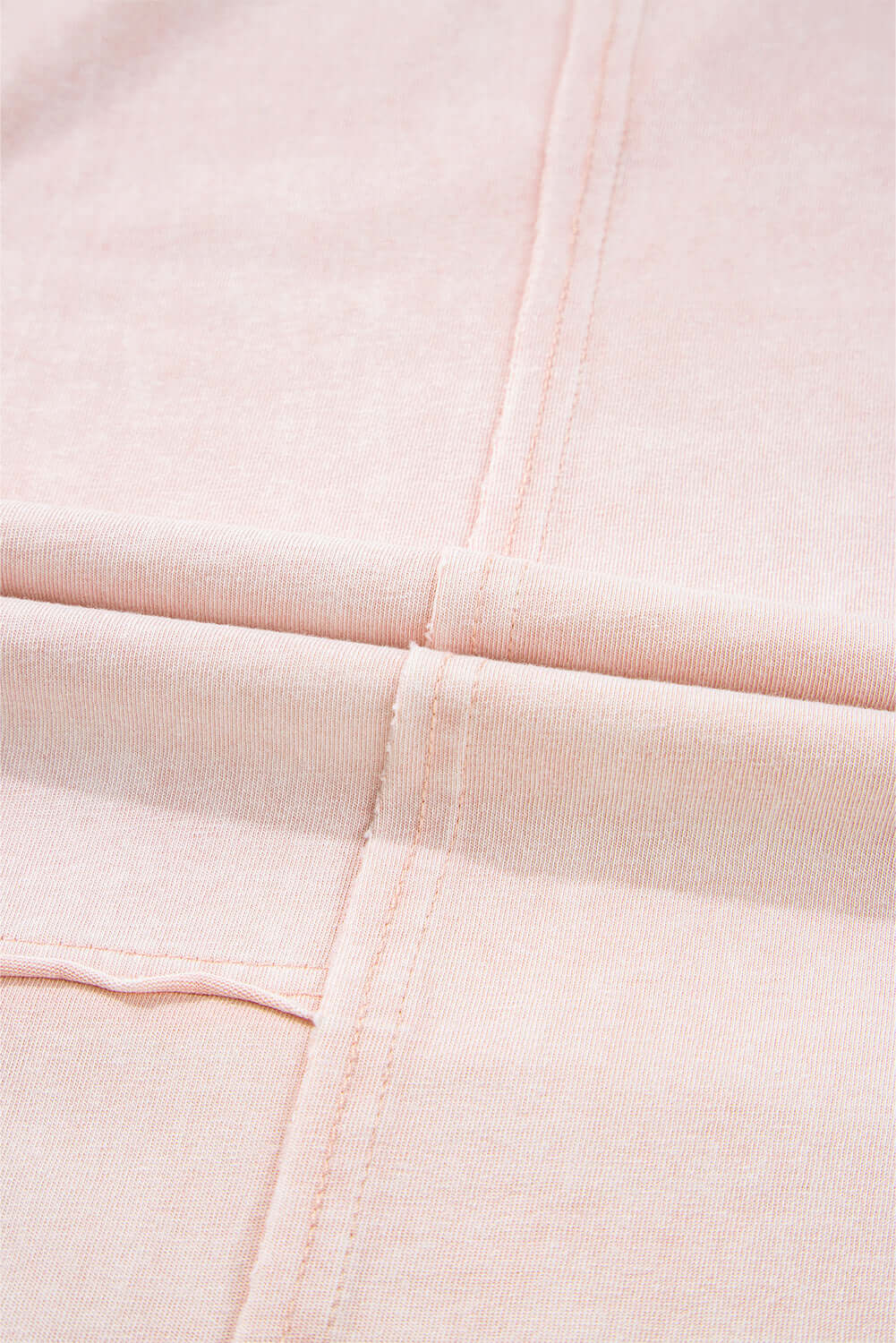 Close-up of the soft pink fabric of Daisy Daydreamer Pants with stitched seams.