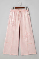 Daisy Daydreamer Pants in pink with flower patches, cropped wide leg design and elastic waistband for boho style.