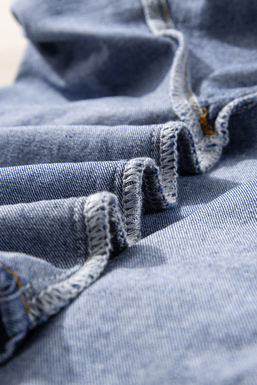 Close-up of high-quality denim fabric with detailed stitching, showcasing the material used in the Denim Darlin Top.