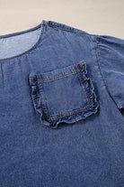 Sophisticated denim blouse with elegant 3/4 sleeves and stylish ruffled chest pocket, made from 100% cotton.