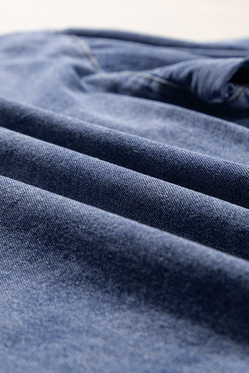 Close-up view of Denim Darlin Top fabric showcasing durable, fashionable denim texture in rich blue hue.