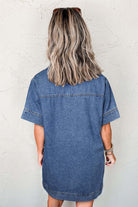 Back view of a woman in a short-sleeve blue jean dress, showcasing relaxed fit and denim texture.