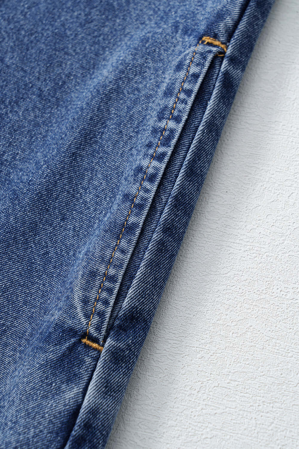 Close-up of denim fabric showcasing stitching details on the Blue Jean Breeze Dress, perfect for stylish summer wear.