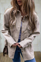 Woman wearing taupe LOOKING FORWARD jacket with turn down collar and flap pockets, paired with jeans for a stylish look.