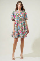 Jacey Dress by Sugarlips featuring colorful flower pattern, split ruffle neckline, and Babydoll silhouette.