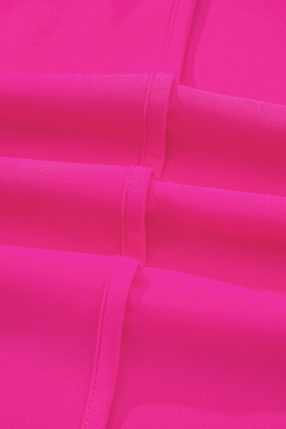 Close-up of hot pink fabric with detailed seaming, showcasing the vibrant color and texture of the Berry Brilliance Top.