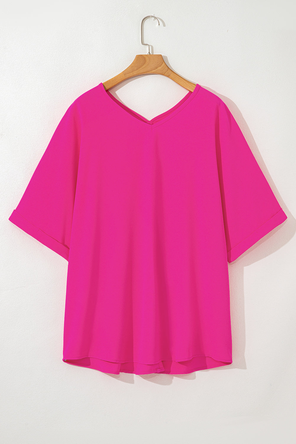 Hot pink plus size V-neck top with cuffed sleeves and a relaxed hemline, perfect for a bold, stylish look.
