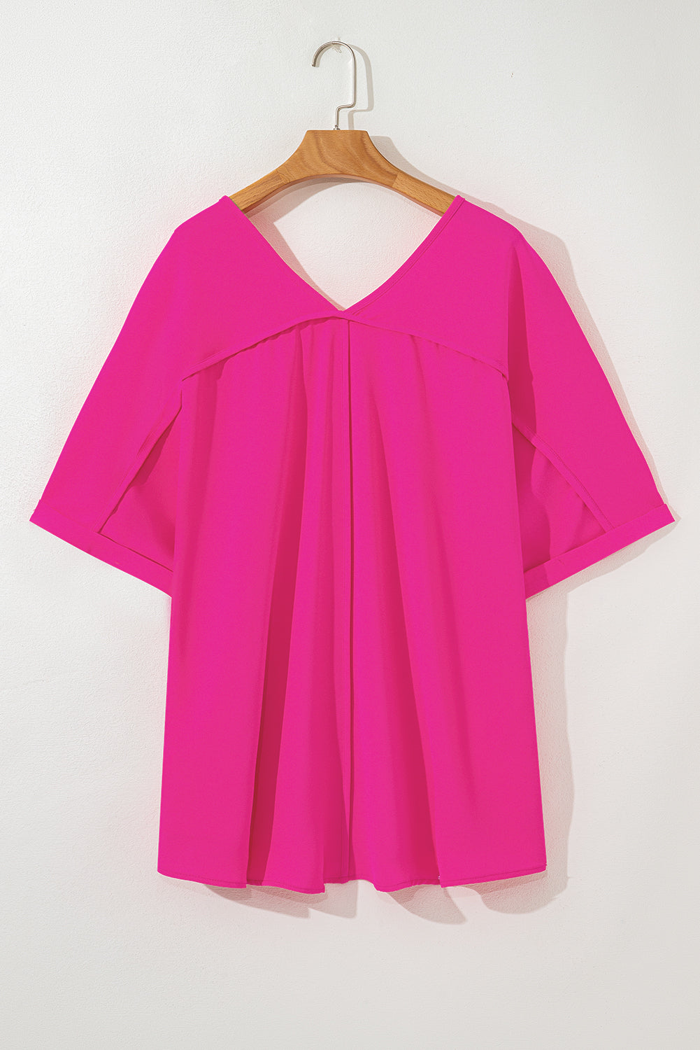Plus size hot pink V-neck top with cuffed sleeves and seamed back, perfect for a bold fashion statement.