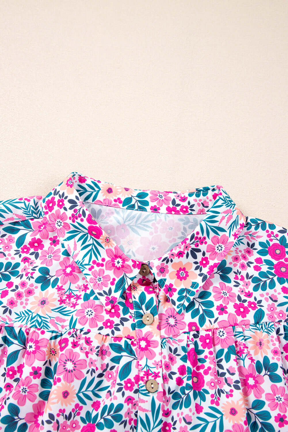Close-up of the Heirloom Blooms Dress collar with a vibrant pink floral print and button details.