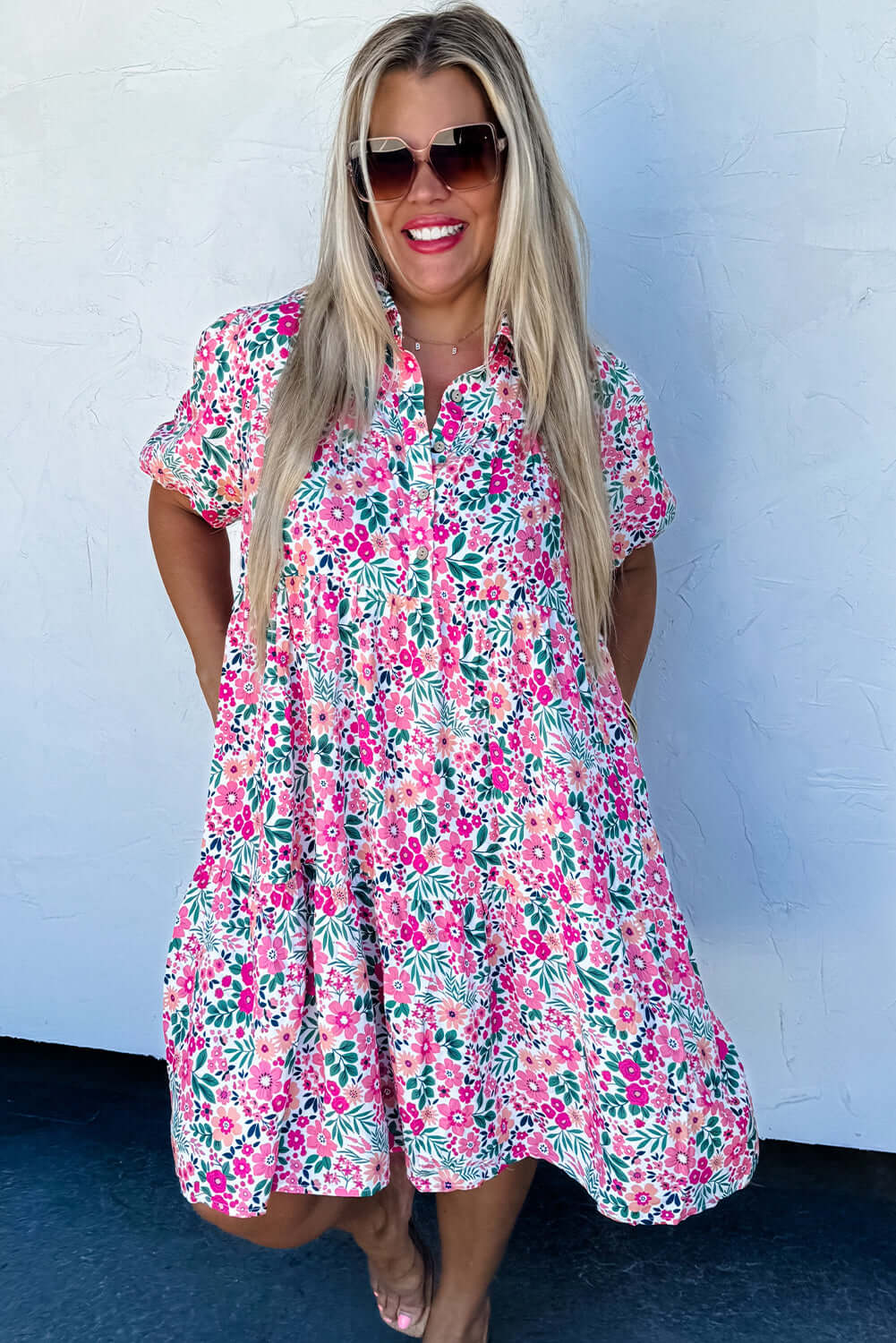 Model wearing Heirloom Blooms Dress with vibrant pink floral print and puff sleeves, perfect for spring and summer.