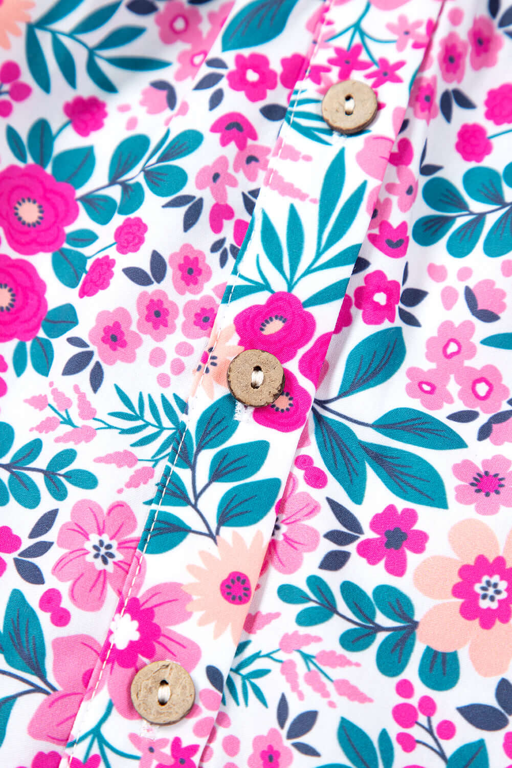 Close-up of the vibrant pink floral print and buttons on the Heirloom Blooms Dress fabric.