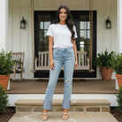Model wearing RISEN VANESSA JEANS with a white t-shirt and sandals on a porch.
