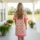 A woman wearing the MY HAPPY PLACE DRESS - She + Sky, showcasing its bold fan-inspired print and vibrant pink trim.
