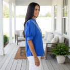 BRIGHT FUTURE TOP - Entro in vibrant blue, featuring embroidered V-neck and stylish puff sleeves, perfect for everyday comfort.