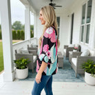 Model wearing BRIGHTER DAYS TOP - Umgee with floral print, showcasing vibrant style and comfort on a porch.