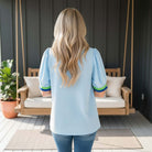 BREATHE EASY TOP - Jodifl worn by a woman from behind, featuring a soft baby blue color and stylish green and blue accents.