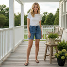 JUDY BLUE MIDRISE DAKOTA SHORTS worn by a model on a porch with a modern, stylish look and comfortable fit.