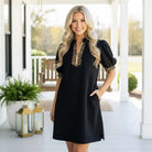 Model wearing the BOLD MOVES DRESS, featuring a leopard trim and zip-up collared neckline, exuding confidence.