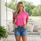 Woman in pink shirt wearing Judy Blue Ryleigh Shorts, styled for summer with a smile.