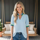 BREATHE EASY TOP - Jodifl model wearing a blue blouse with green and blue accents, styled casually outdoors.