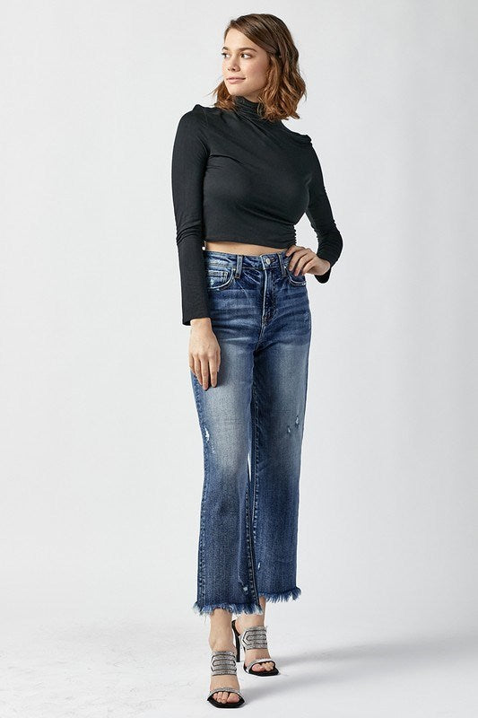 Model in RISEN Bianca Jeans with frayed hem, paired with a black top and stylish heels.